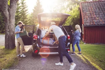 Une famille remplit sa voiture de valises